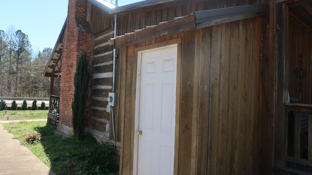 entrance to property with a chimney and fence