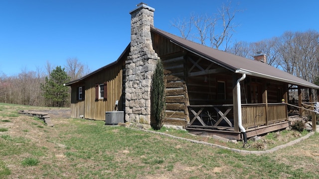 view of home's exterior with a chimney and central AC