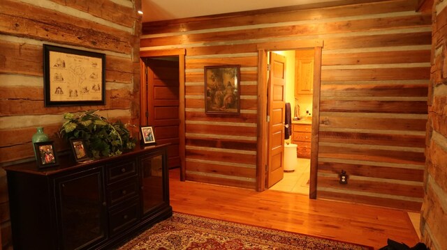 hall with wooden walls and light wood-type flooring