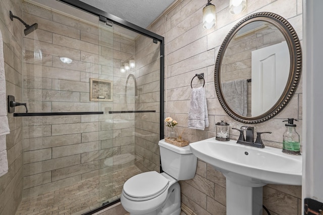 bathroom featuring toilet, a shower stall, a textured ceiling, decorative backsplash, and tile walls