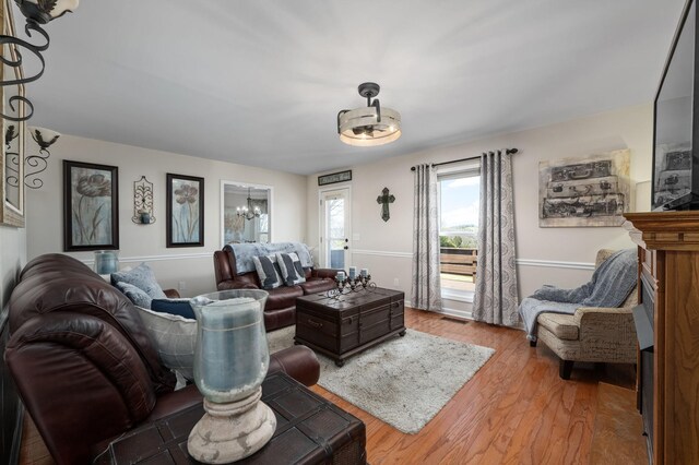 living room featuring visible vents, wood finished floors, and a notable chandelier