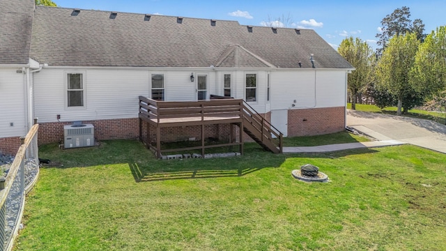 rear view of house featuring a fire pit, stairs, a deck, a lawn, and central AC