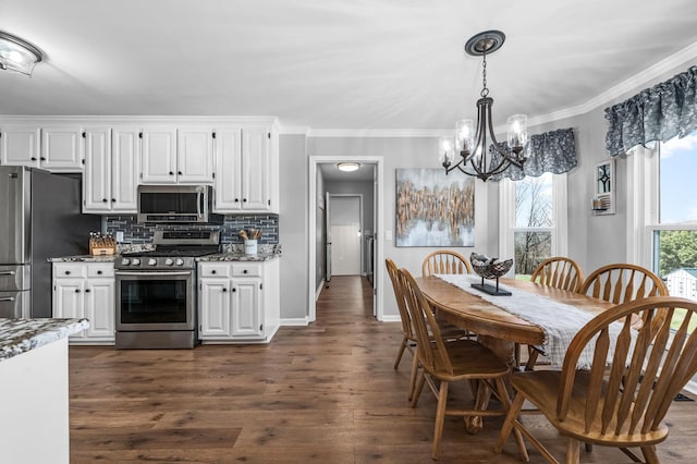 kitchen with appliances with stainless steel finishes, an inviting chandelier, white cabinets, decorative backsplash, and dark wood-style flooring