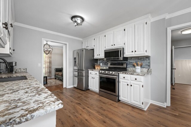 kitchen featuring crown molding, a sink, white cabinets, and appliances with stainless steel finishes