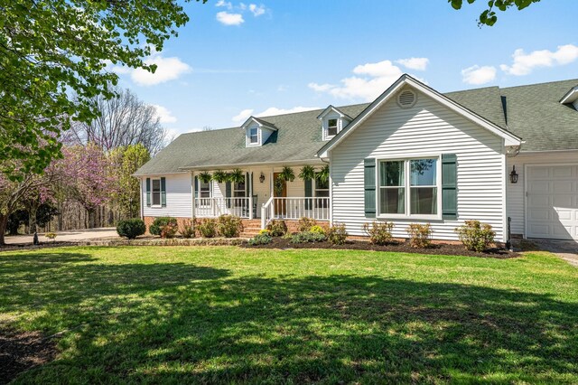 cape cod-style house featuring covered porch, roof with shingles, an attached garage, and a front lawn