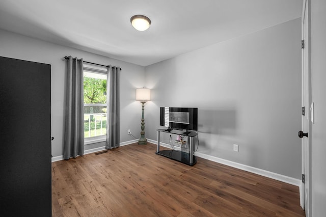 miscellaneous room with baseboards, visible vents, and wood finished floors
