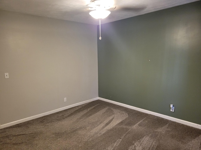 empty room with baseboards and dark colored carpet