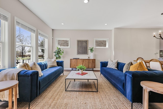 living room featuring baseboards, a notable chandelier, and recessed lighting