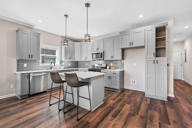 kitchen featuring a sink, gray cabinets, appliances with stainless steel finishes, and dark wood-style floors