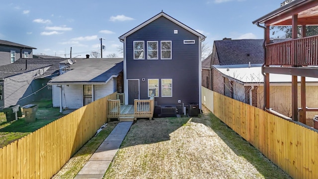 rear view of house with a fenced backyard and a wooden deck