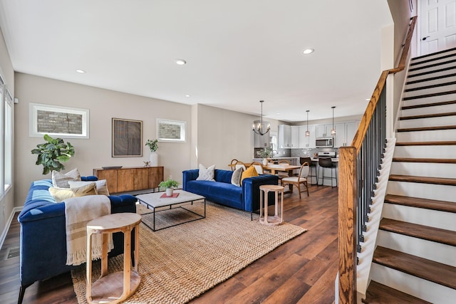 living room with stairs, recessed lighting, dark wood finished floors, visible vents, and a notable chandelier