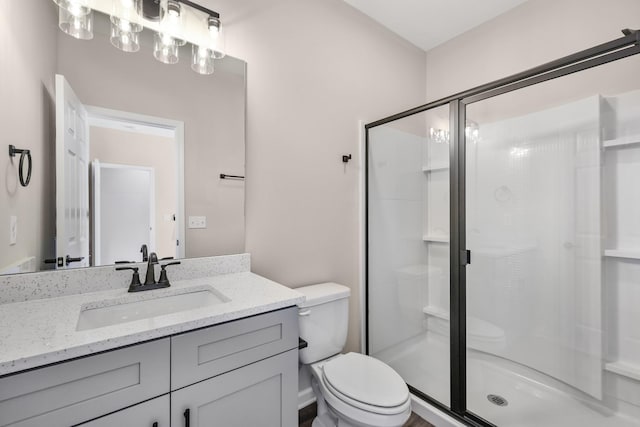 full bath featuring vanity, toilet, and a shower stall