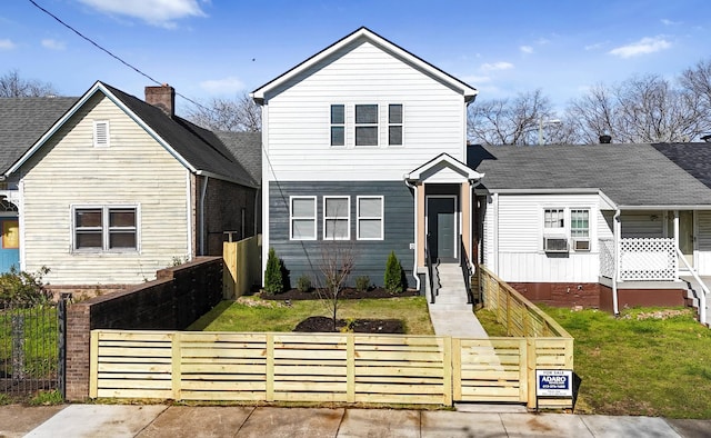 traditional-style house featuring a front yard and a fenced front yard