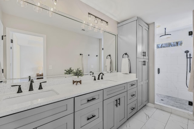 full bathroom featuring marble finish floor, double vanity, a stall shower, and a sink