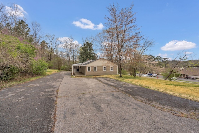 view of front facade featuring aphalt driveway and a chimney