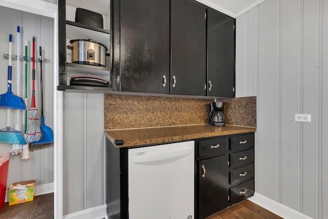 kitchen with decorative backsplash, dark countertops, dark wood finished floors, dark cabinets, and white dishwasher