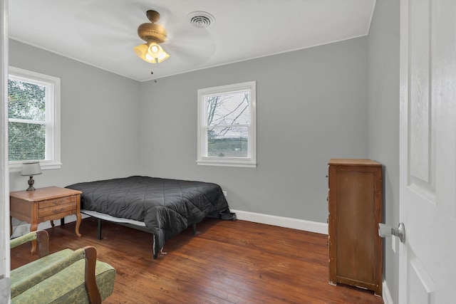bedroom with baseboards, visible vents, ceiling fan, and hardwood / wood-style flooring