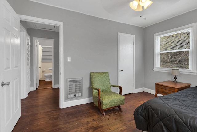 bedroom with attic access, baseboards, wood finished floors, and heating unit