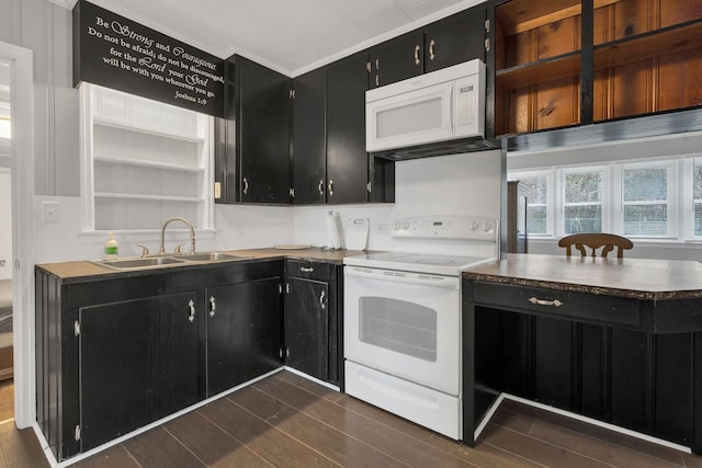 kitchen featuring wood tiled floor, a sink, dark cabinets, and white appliances