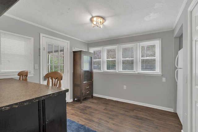 dining area with a textured ceiling, crown molding, baseboards, and dark wood-style flooring