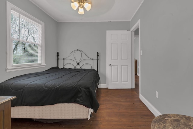 bedroom with baseboards, wood finished floors, and ornamental molding