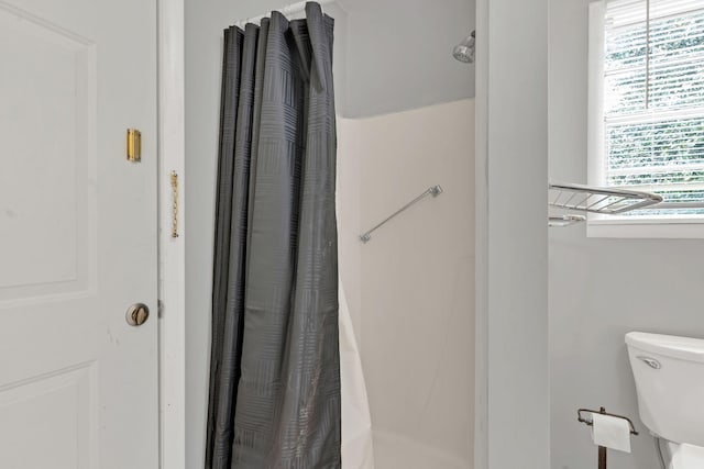 bathroom with toilet and curtained shower