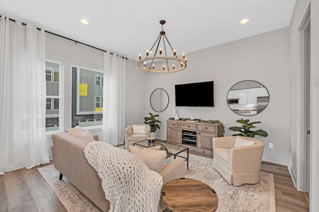 living area featuring an inviting chandelier, recessed lighting, baseboards, and light wood-type flooring