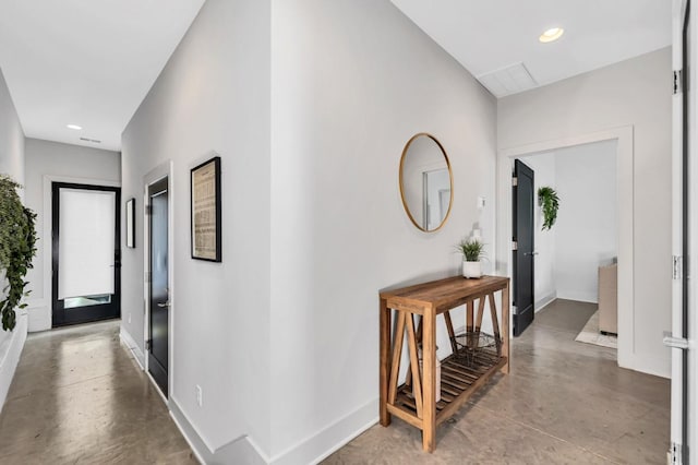 corridor featuring baseboards, finished concrete floors, and recessed lighting