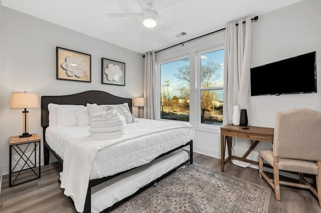 bedroom with wood finished floors, baseboards, and visible vents