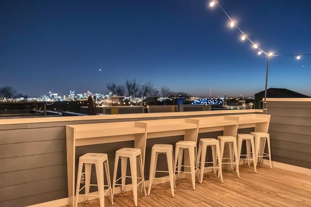deck at twilight featuring a view of city lights and outdoor dry bar