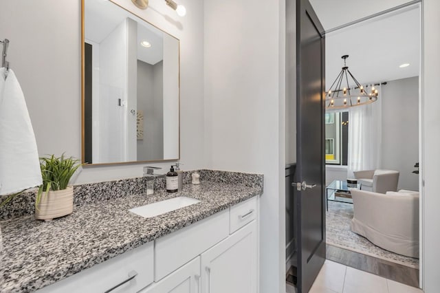 bathroom featuring a notable chandelier, recessed lighting, tile patterned flooring, and vanity