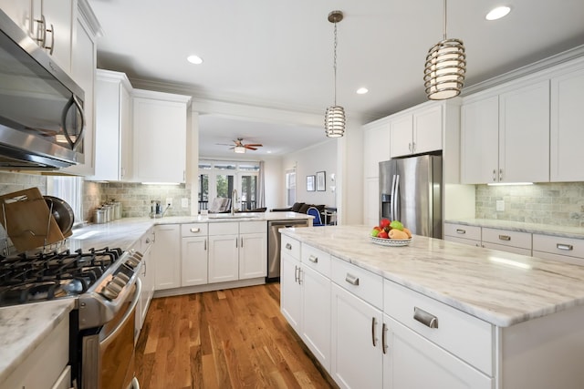 5311 Tennessee Ave Unit A, Nashville, TN 37209 - kitchen with white cabinets, stainless steel appliances, a sink, light wood-style floors, and backsplash