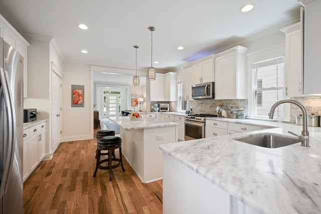 5311 Tennessee Ave Unit A, Nashville, TN 37209 - kitchen with light stone countertops, stainless steel appliances, a kitchen island, a sink, and backsplash