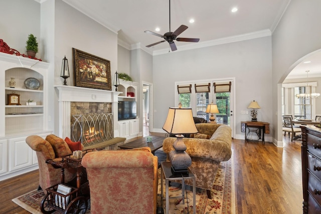 1194 Meadow Bridge Ln, Arrington, TN 37014 - living room with ornamental molding, a stone fireplace, arched walkways, dark wood-type flooring, and ceiling fan with notable chandelier