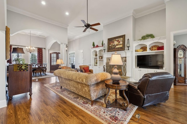 1194 Meadow Bridge Ln, Arrington, TN 37014 - living room with decorative columns, a high ceiling, ceiling fan with notable chandelier, arched walkways, and dark wood-type flooring