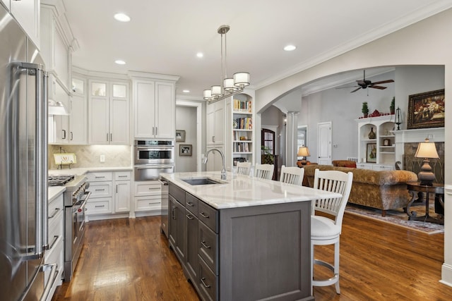 1194 Meadow Bridge Ln, Arrington, TN 37014 - kitchen featuring decorative columns, a sink, a ceiling fan, premium appliances, and arched walkways