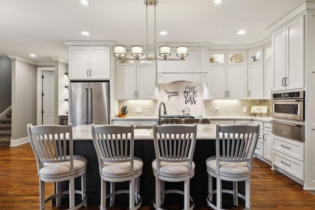 1194 Meadow Bridge Ln, Arrington, TN 37014 - kitchen with white cabinets, a kitchen island with sink, appliances with stainless steel finishes, dark wood-type flooring, and a warming drawer