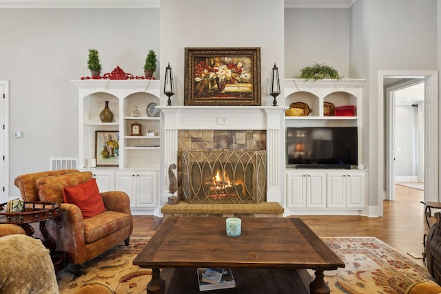 1194 Meadow Bridge Ln, Arrington, TN 37014 - living room featuring a fireplace, wood finished floors, built in features, visible vents, and ornamental molding