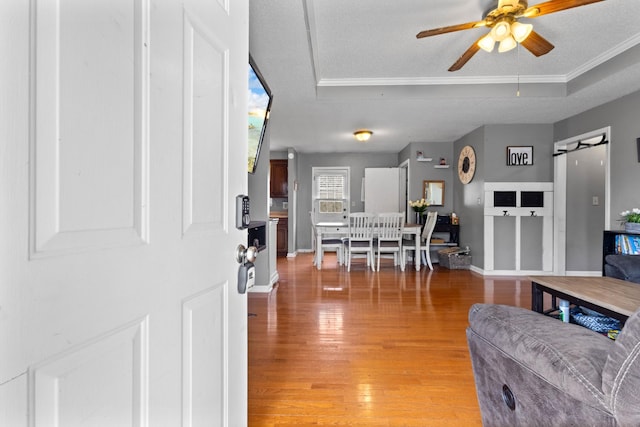 740 Acorn Dr, Clarksville, TN 37043 - living area featuring crown molding, light wood finished floors, baseboards, ceiling fan, and a raised ceiling