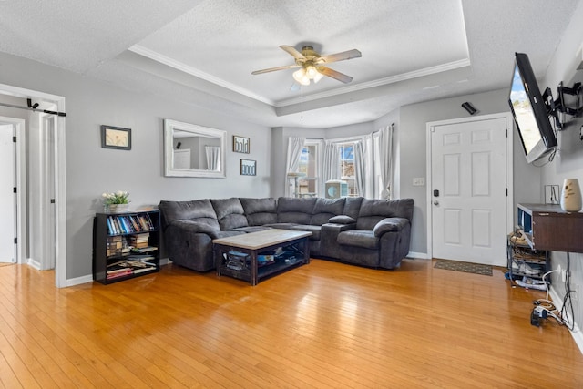 740 Acorn Dr, Clarksville, TN 37043 - living room featuring a tray ceiling, light wood-type flooring, baseboards, a textured ceiling, and a ceiling fan