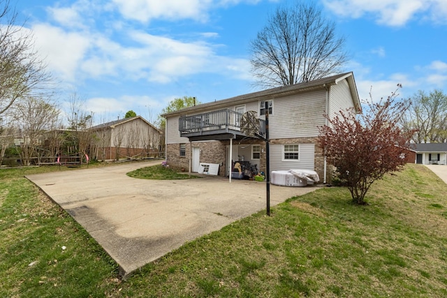 740 Acorn Dr, Clarksville, TN 37043 - back of house featuring concrete driveway, a deck, brick siding, and a yard