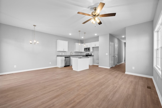 837 Cumberland Dr, Clarksville, TN 37040 - unfurnished living room featuring baseboards, ceiling fan with notable chandelier, and light wood-style floors
