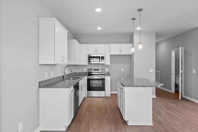 837 Cumberland Dr, Clarksville, TN 37040 - kitchen featuring a kitchen island, appliances with stainless steel finishes, a sink, white cabinets, and dark wood-type flooring