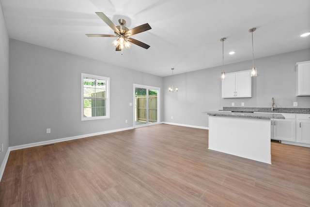 837 Cumberland Dr, Clarksville, TN 37040 - kitchen with light wood-style floors, baseboards, a kitchen island, and ceiling fan with notable chandelier