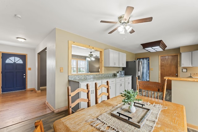 dining room featuring baseboards, wood finished floors, and a ceiling fan