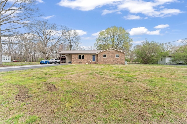 view of front facade with metal roof, driveway, a carport, and a front lawn