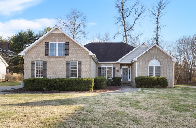 view of front of property featuring a front lawn and brick siding