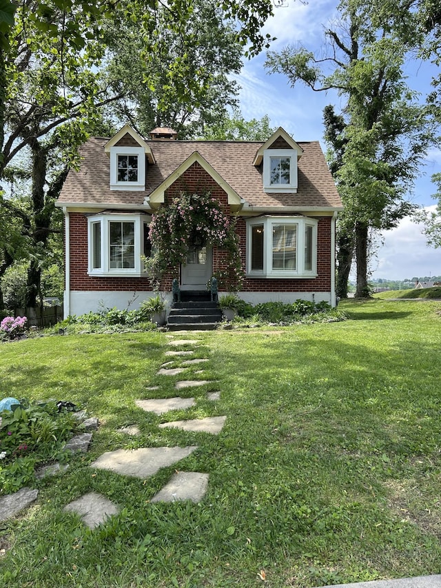409 W 6th St, Columbia, TN 38401 - cape cod home featuring brick siding, a front lawn, and roof with shingles