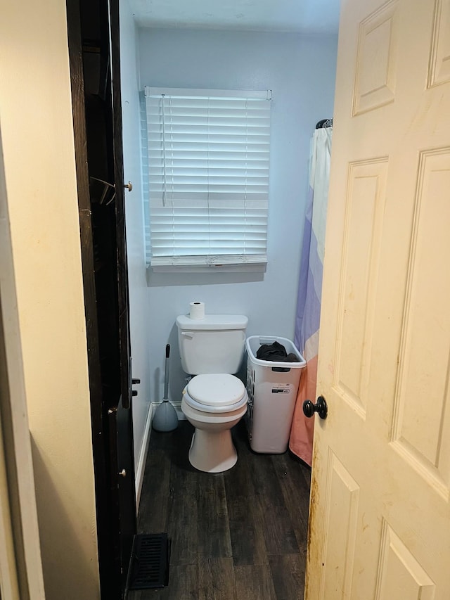 bathroom featuring toilet, visible vents, and wood finished floors