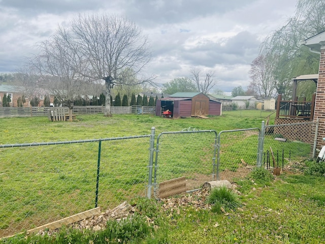 view of yard featuring a rural view, an outbuilding, fence, and a storage shed